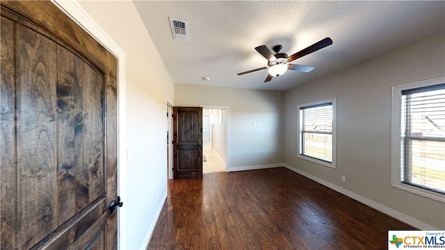 unfurnished bedroom with dark wood-type flooring, ceiling fan, and a textured ceiling