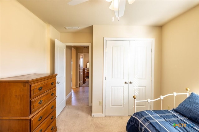 carpeted bedroom featuring ceiling fan and a closet