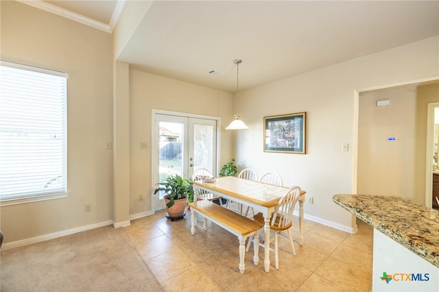 dining room with a healthy amount of sunlight, french doors, light tile patterned floors, and crown molding