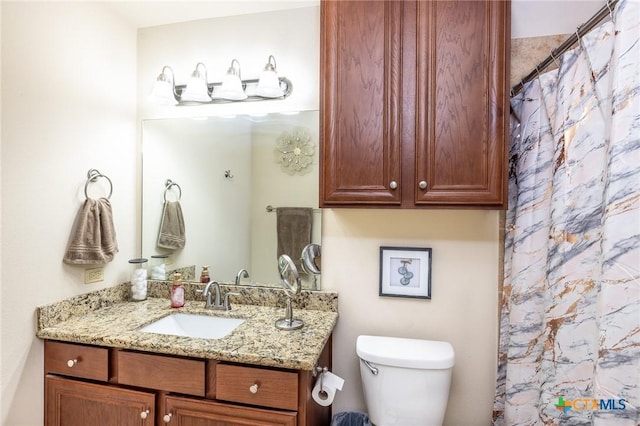 bathroom with toilet, vanity, and a shower with curtain