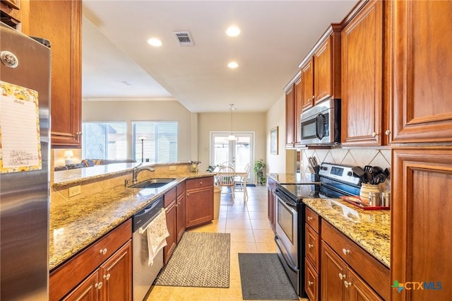 kitchen with sink, hanging light fixtures, stainless steel appliances, light tile patterned floors, and light stone counters