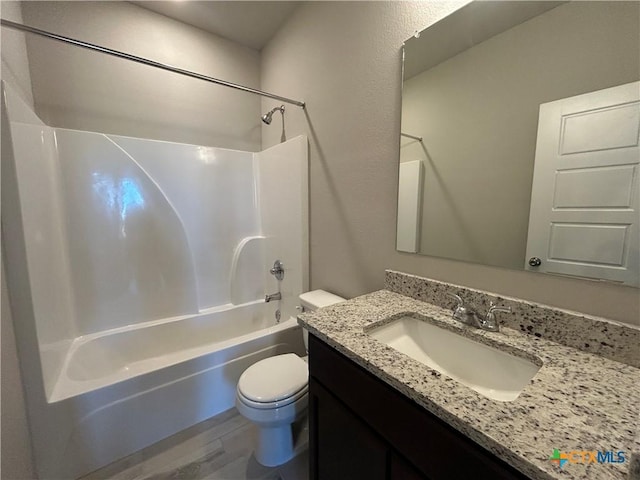 full bathroom with hardwood / wood-style flooring, vanity, washtub / shower combination, and toilet