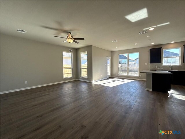 kitchen featuring sink, appliances with stainless steel finishes, dark brown cabinets, wood-type flooring, and a kitchen island