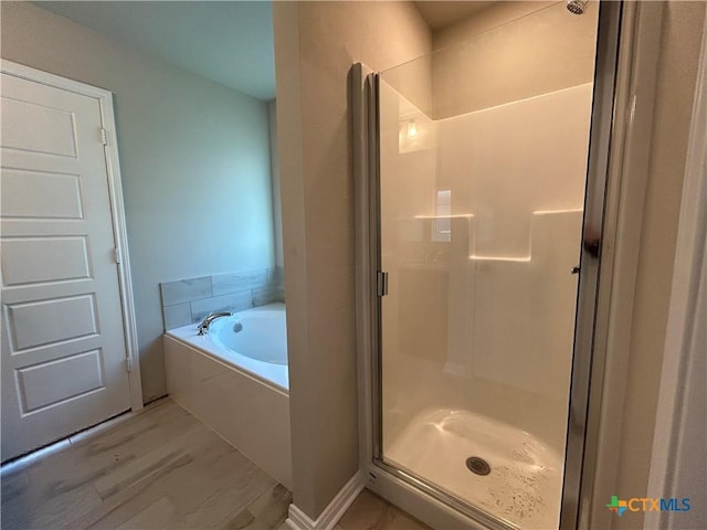 bathroom featuring hardwood / wood-style floors and shower with separate bathtub