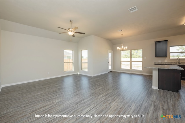 unfurnished living room with ceiling fan with notable chandelier, a wealth of natural light, dark hardwood / wood-style floors, and sink