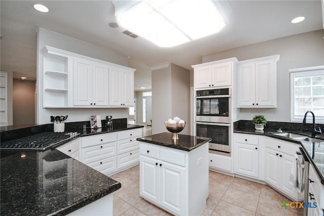 kitchen with stainless steel appliances, open shelves, light tile patterned flooring, and a sink