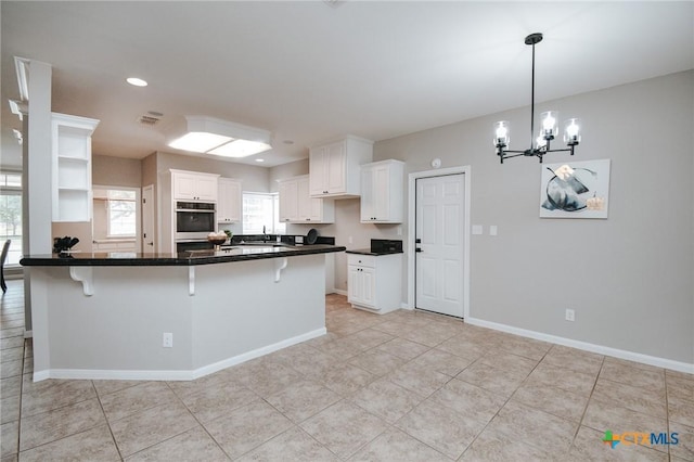 kitchen with a breakfast bar, stainless steel double oven, and dark countertops