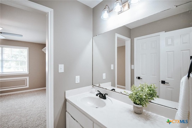 bathroom featuring baseboards, a ceiling fan, and vanity