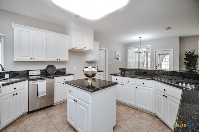 kitchen with a notable chandelier, light tile patterned floors, stainless steel dishwasher, white cabinetry, and a sink