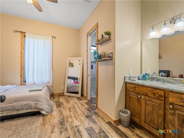 12093 Sulphur Springs Rd, Adkins, TX 78101 - bedroom with light wood-style floors, a sink, baseboards, and a ceiling fan
