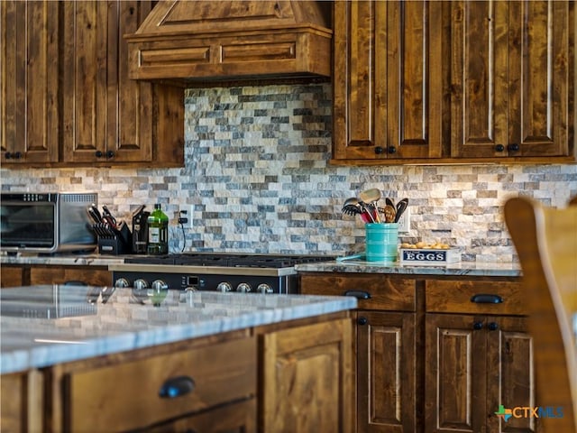 12093 Sulphur Springs Rd, Adkins, TX 78101 - kitchen featuring premium range hood, tasteful backsplash, stainless steel gas stovetop, and dark brown cabinets