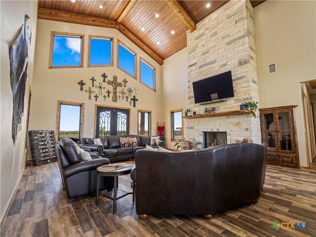 12093 Sulphur Springs Rd, Adkins, TX 78101 - living room with wood ceiling, high vaulted ceiling, a stone fireplace, dark wood-style flooring, and beam ceiling