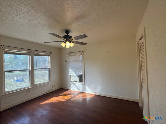 unfurnished room with a textured ceiling, dark hardwood / wood-style floors, ceiling fan, and cooling unit