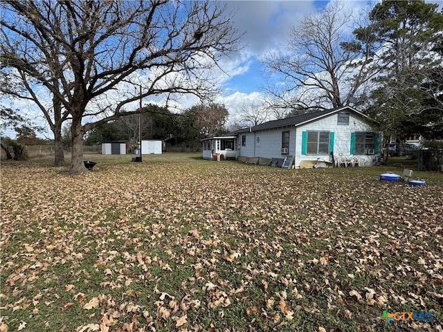 view of yard with a sunroom and a storage unit