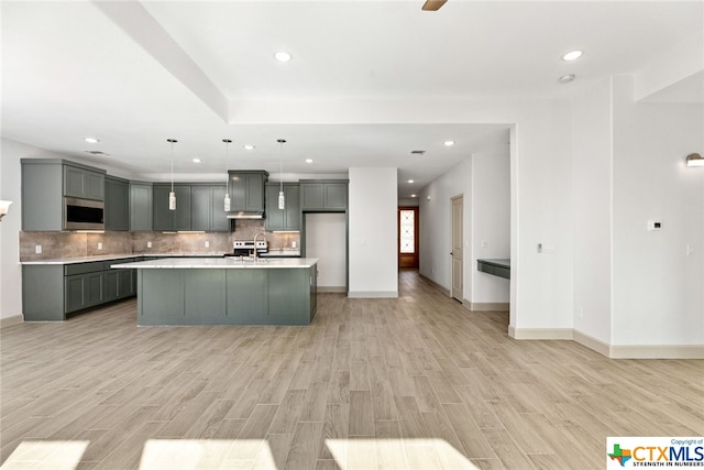 kitchen featuring backsplash, light hardwood / wood-style floors, pendant lighting, gray cabinets, and appliances with stainless steel finishes