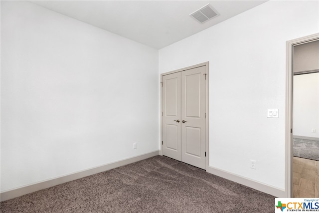 unfurnished bedroom with dark carpet