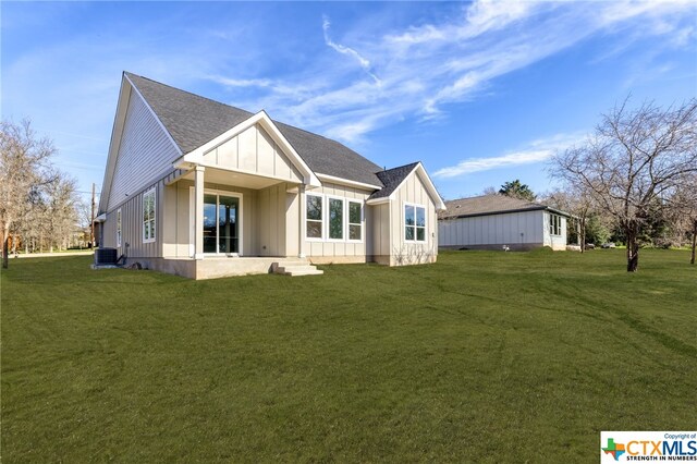 back of house featuring a lawn and cooling unit