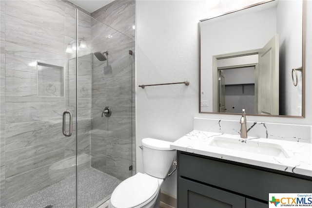 bathroom with vanity, toilet, and a shower with shower door