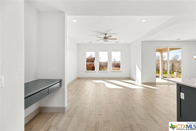 unfurnished living room with ceiling fan