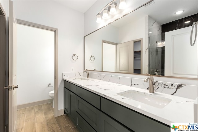 bathroom with an enclosed shower, vanity, and toilet