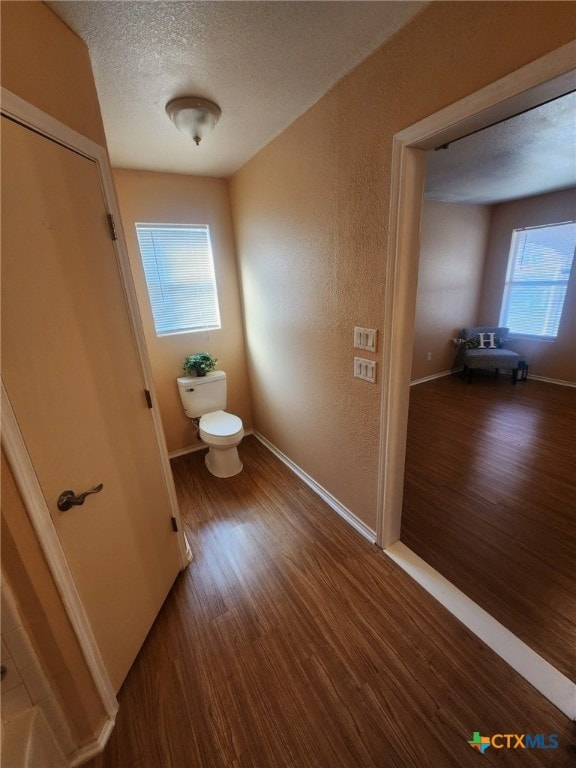 bathroom with toilet, hardwood / wood-style flooring, and a textured ceiling