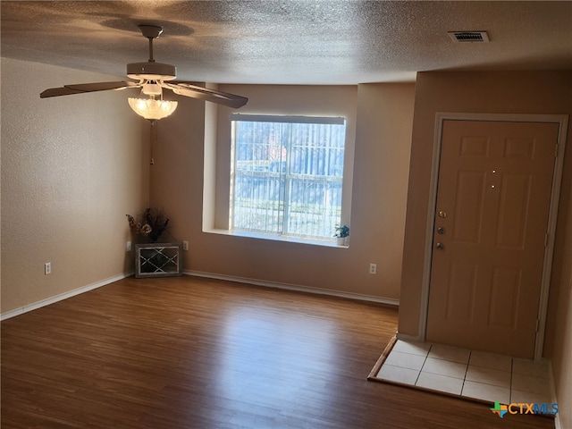 entrance foyer with ceiling fan, wood-type flooring, and a textured ceiling