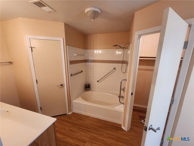 bathroom featuring hardwood / wood-style flooring and tiled shower / bath combo