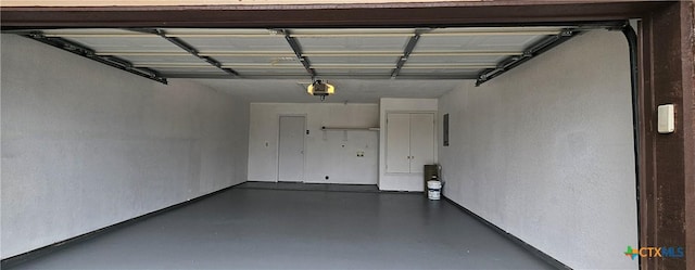 garage with a garage door opener and electric panel