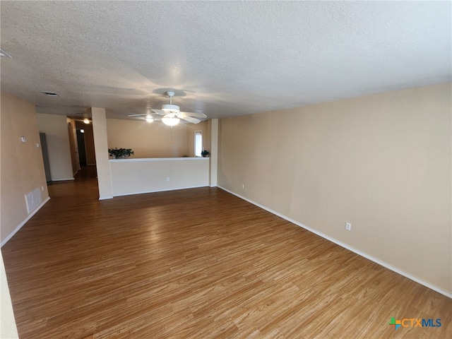 unfurnished room with hardwood / wood-style floors, ceiling fan, and a textured ceiling