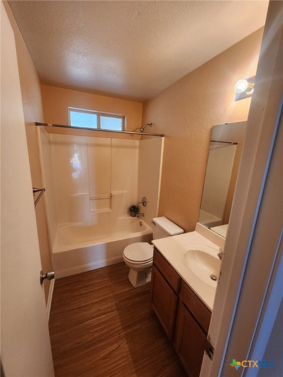 full bathroom with bathing tub / shower combination, toilet, wood-type flooring, a textured ceiling, and vanity