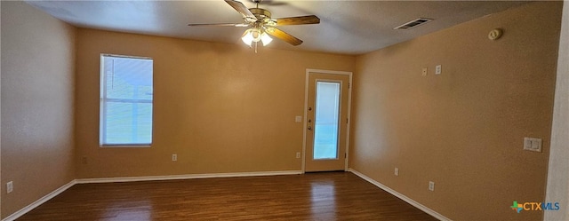 unfurnished room with dark wood-type flooring, ceiling fan, and a wealth of natural light