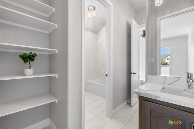 full bathroom with marble finish floor, vanity, baseboards, and bathing tub / shower combination