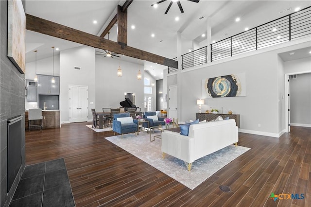 living area featuring dark wood-style floors, beam ceiling, a ceiling fan, high vaulted ceiling, and baseboards