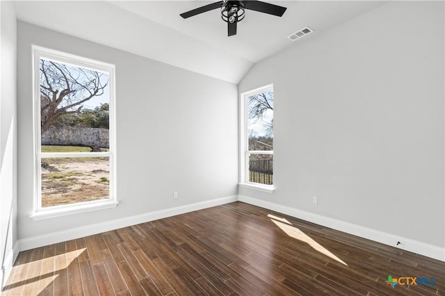 unfurnished room featuring lofted ceiling, visible vents, a ceiling fan, wood finished floors, and baseboards