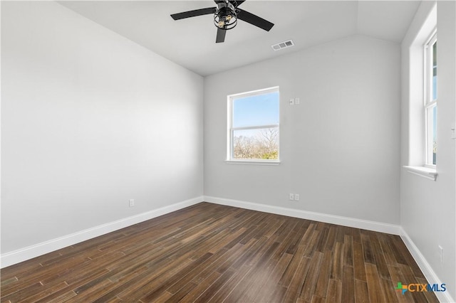 unfurnished room featuring dark wood-type flooring, visible vents, and baseboards