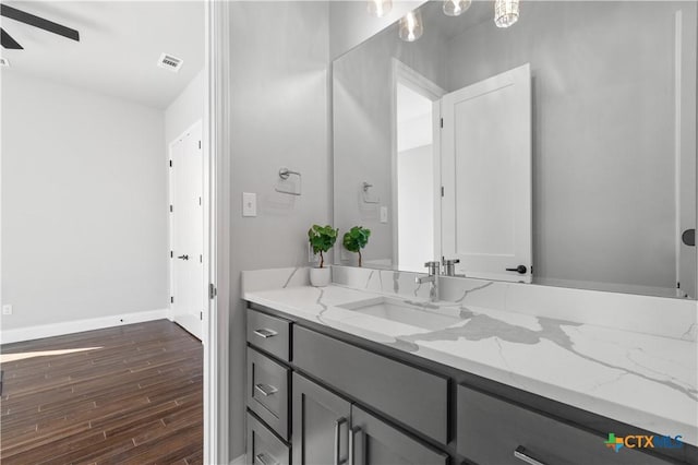 bathroom featuring visible vents, baseboards, ceiling fan, wood finished floors, and vanity