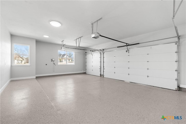 garage with a garage door opener and baseboards