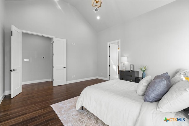 bedroom with high vaulted ceiling, visible vents, dark wood finished floors, and baseboards