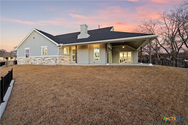 view of front of property with a patio area, fence, and a lawn