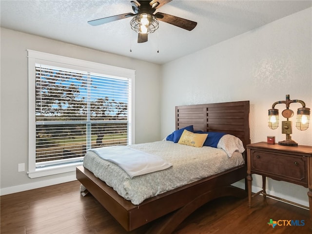 bedroom featuring a textured ceiling, ceiling fan, and dark hardwood / wood-style floors