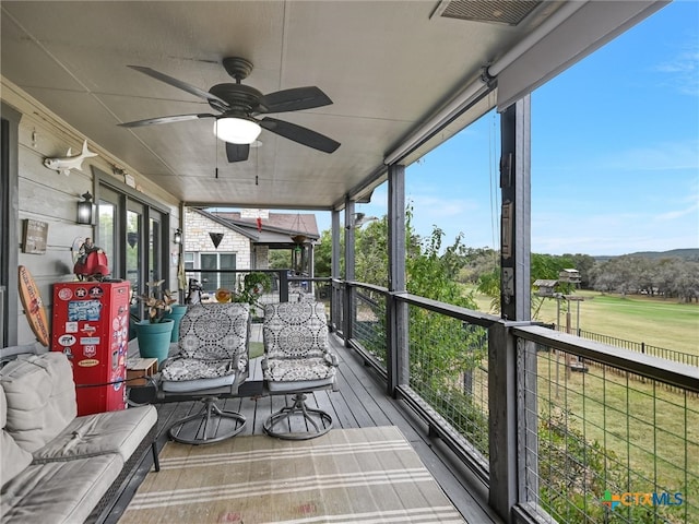 sunroom featuring ceiling fan