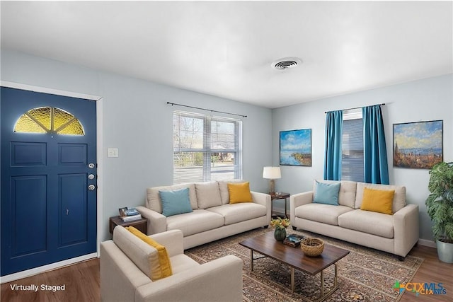 living room featuring dark wood-type flooring, visible vents, and baseboards