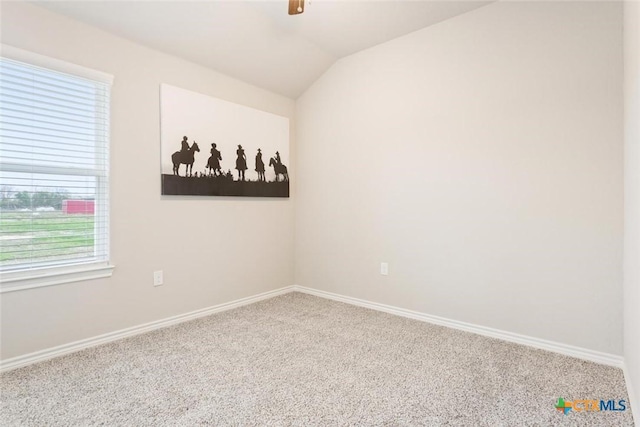 carpeted spare room with lofted ceiling