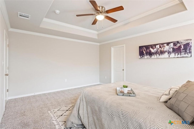 bedroom featuring a raised ceiling, ceiling fan, carpet floors, and ornamental molding