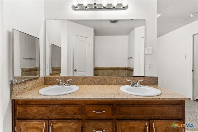 full bathroom featuring double vanity and a sink