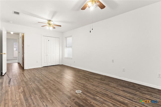 unfurnished bedroom featuring visible vents, dark wood-type flooring, a ceiling fan, a closet, and baseboards