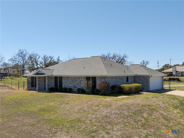 view of side of home with fence, a yard, concrete driveway, a garage, and brick siding