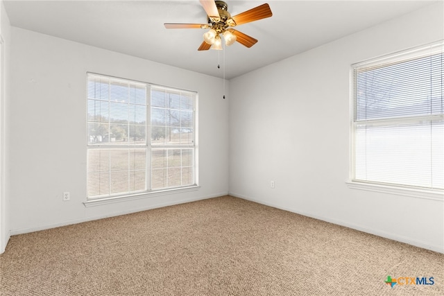 carpeted spare room featuring a ceiling fan