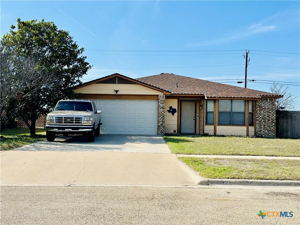 ranch-style home with a front yard and a garage