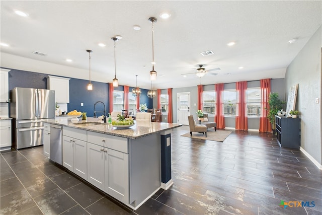 kitchen featuring visible vents, appliances with stainless steel finishes, open floor plan, and a sink